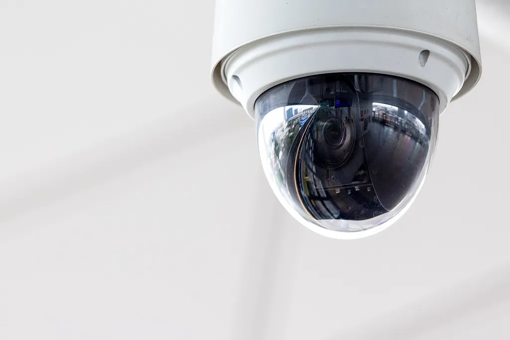 Dome CCTV camera installed to a white ceiling