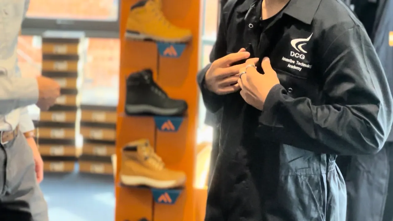 Derby College Automative Student trying on his branded workwear overall
