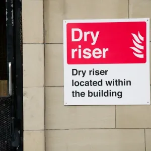 Fire safety sign dry riser located within the building