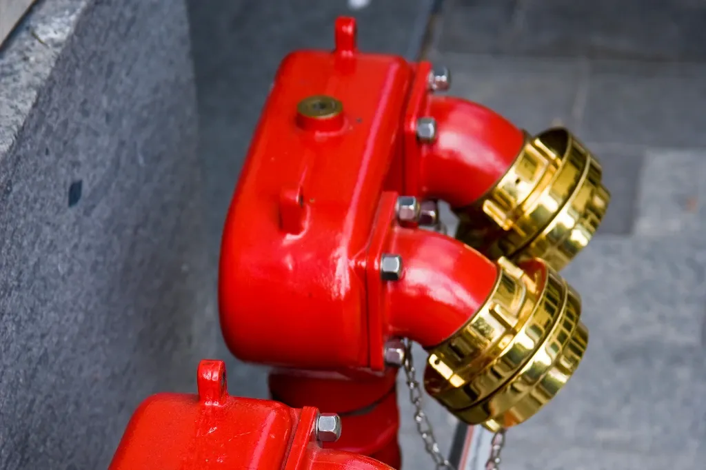 red and gold dry riser inlets next to a wall