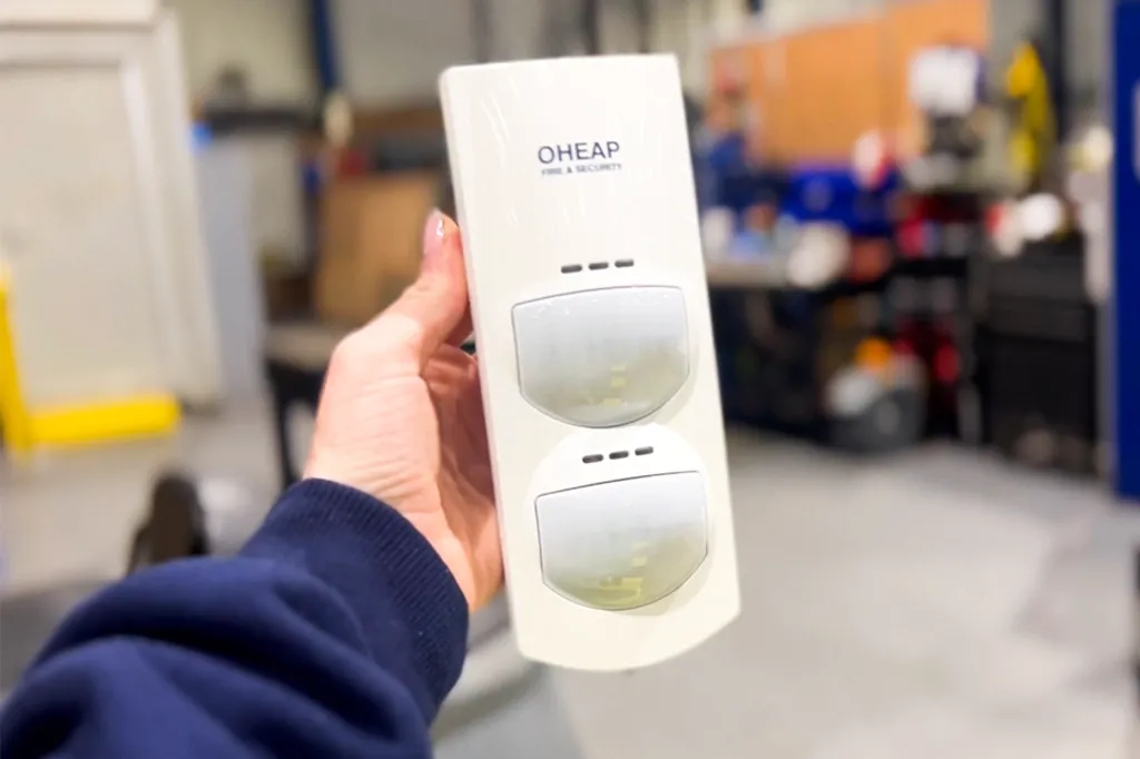 Person holding OHEAP branded intruder alarm detector