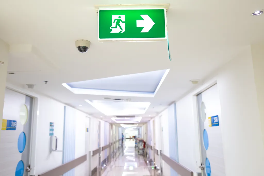 Installed emergency lighting exit right sign in a hospital hallway