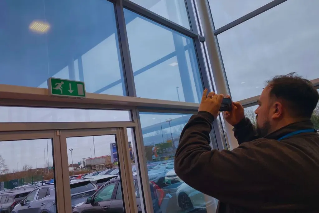 A fire risk assessor taking a picture of a faulty emergency light