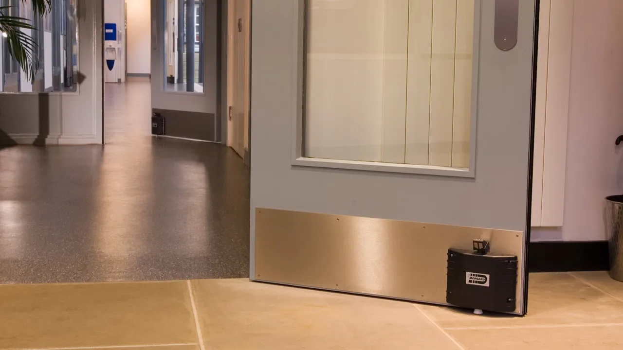 An office fire door being held open with a retainer
