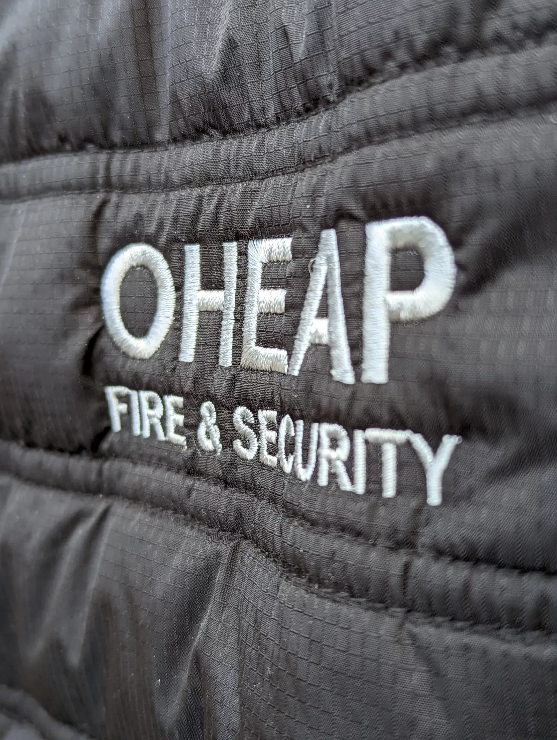 A close up of a jacket with OHEAP Fire & Security embroidered on