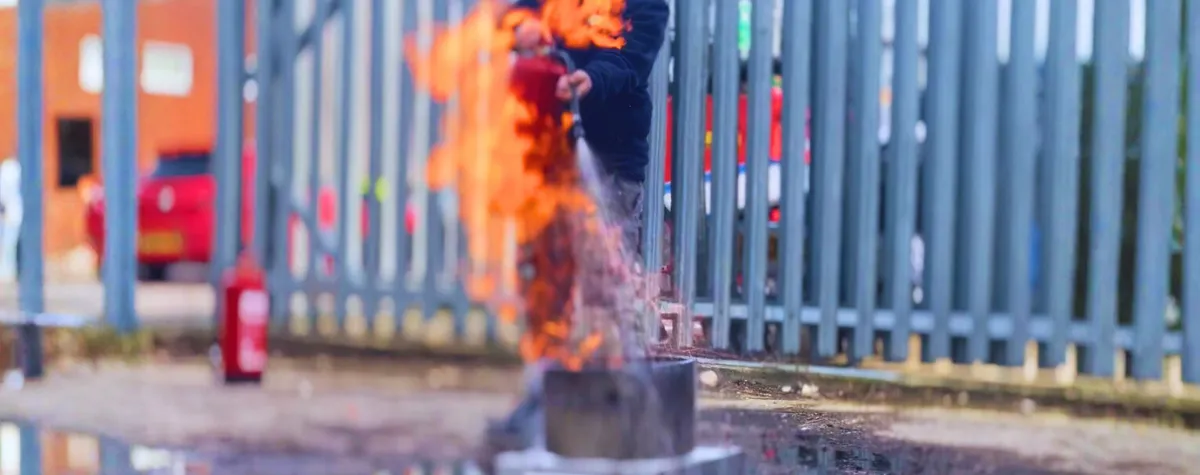 An engineer using a water fire extinguisher during fire extinguisher training