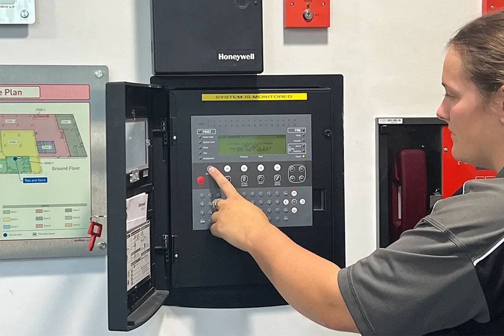 An oheap engineer testing a fire alarm panel