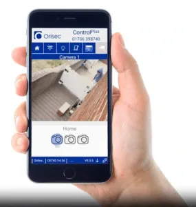 A hand holding a smart phone displaying a security camera feed