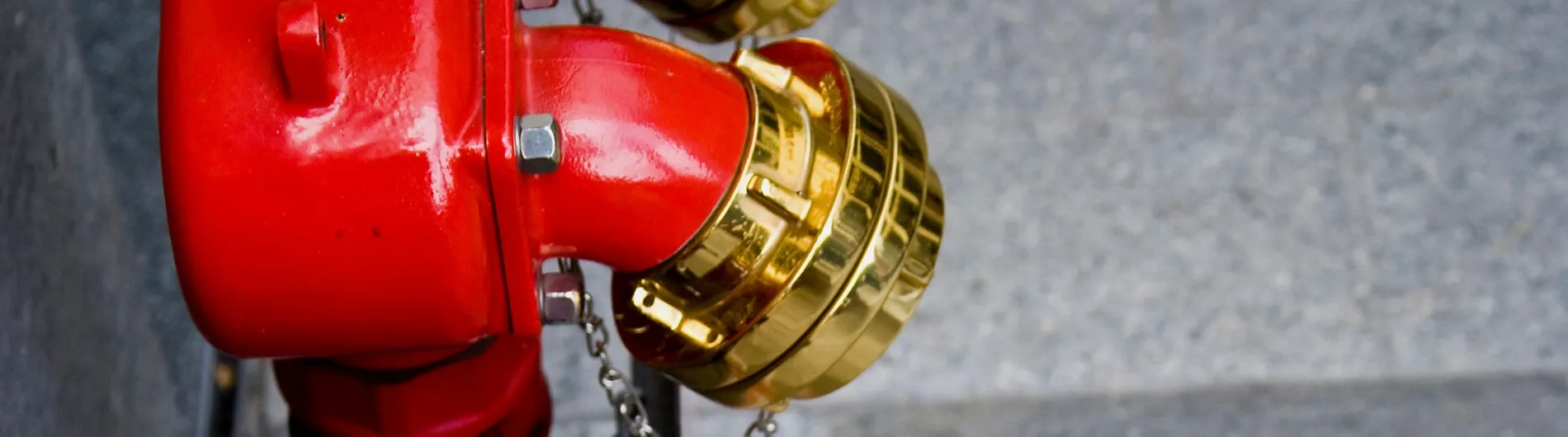 red and gold dry riser inlets next to a wall