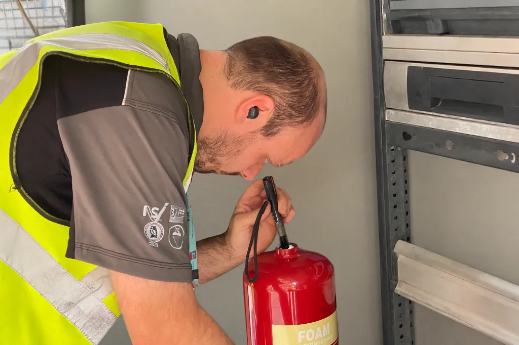 man servicing fire extinguisher